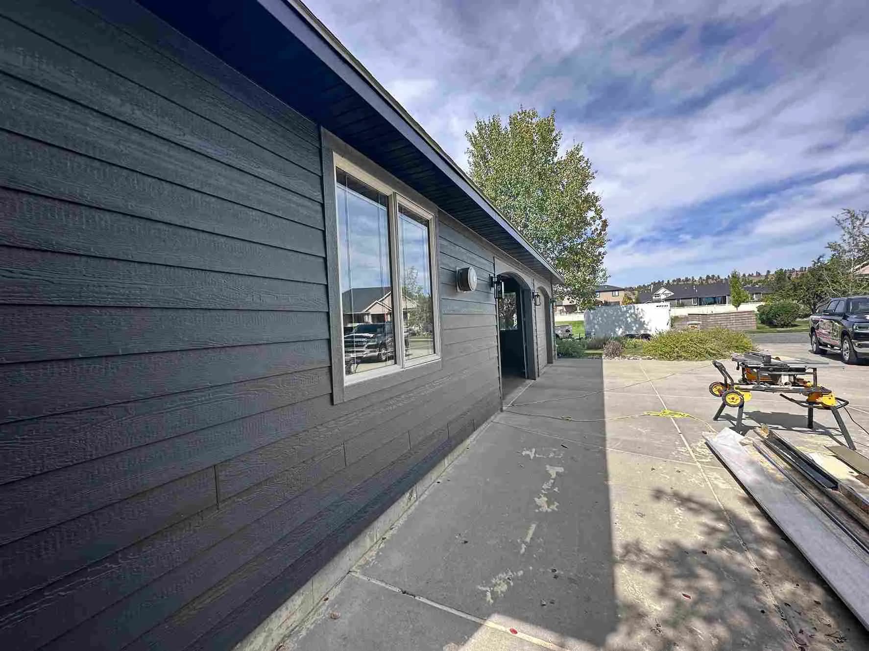 Freshly installed charcoal lap siding with new windows