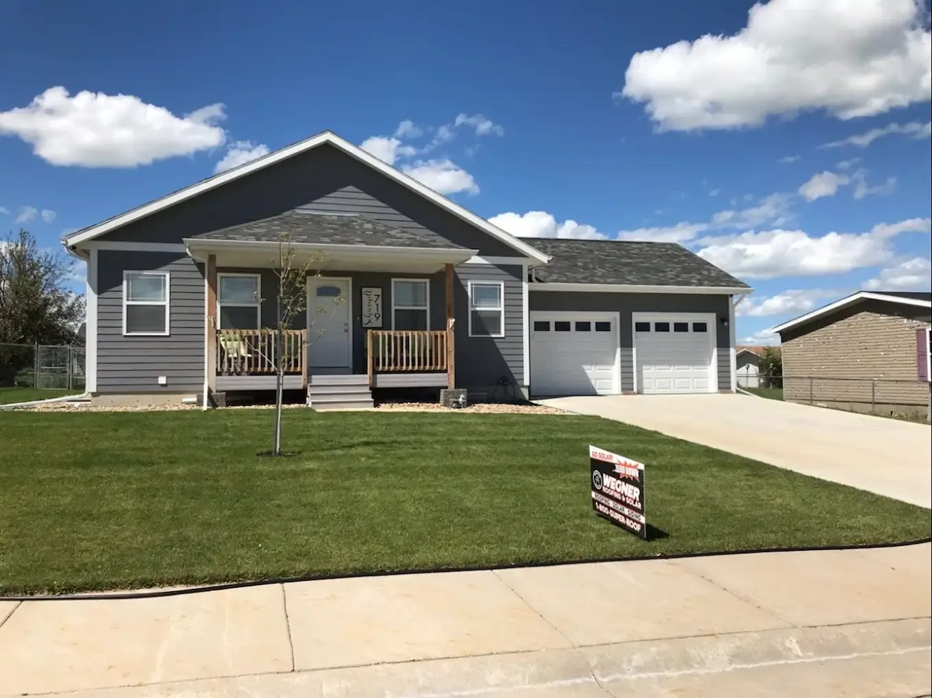 Single-story home with a new roof and siding on a sunny day