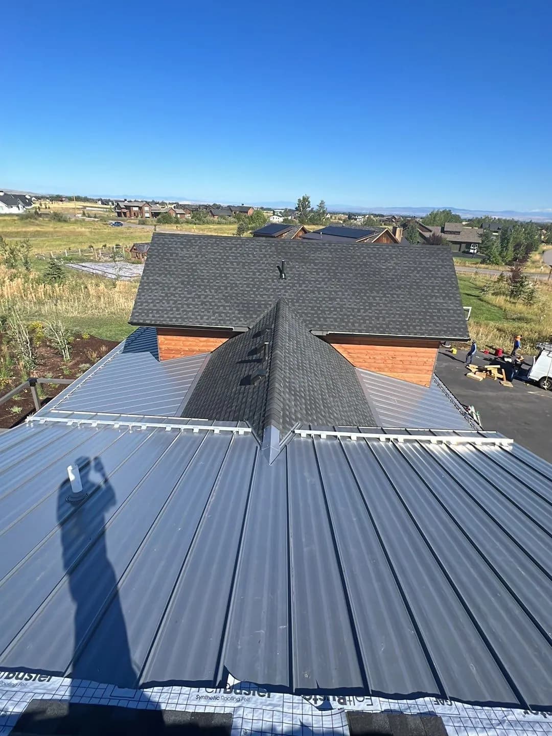 Standing-seam metal roof panels with a shingle ridge section